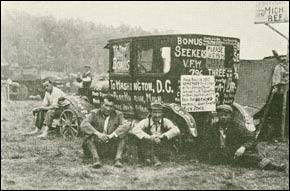 Photo: World War I veterans seated on the ground around a car with slogans painted on it such as 'We want our bonus' and 'Bonus seekers VFW 796'. They are protesting unpaid pensions. Credit: Wisconsin Historical Society