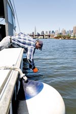 John
Lipscomb, patrol boat captain for Hudson Riverkeeper, takes a sample to test the polluted waters of
Newtown Creek.