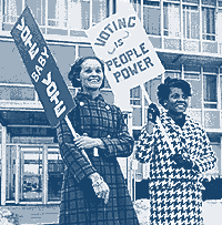 Two women from the 1960s hold signs that say 'Voting is people power!' and 'Vote Baby Vote!'