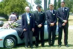 4 guys in front of shrouded EV1 at the EV1 mock funeral